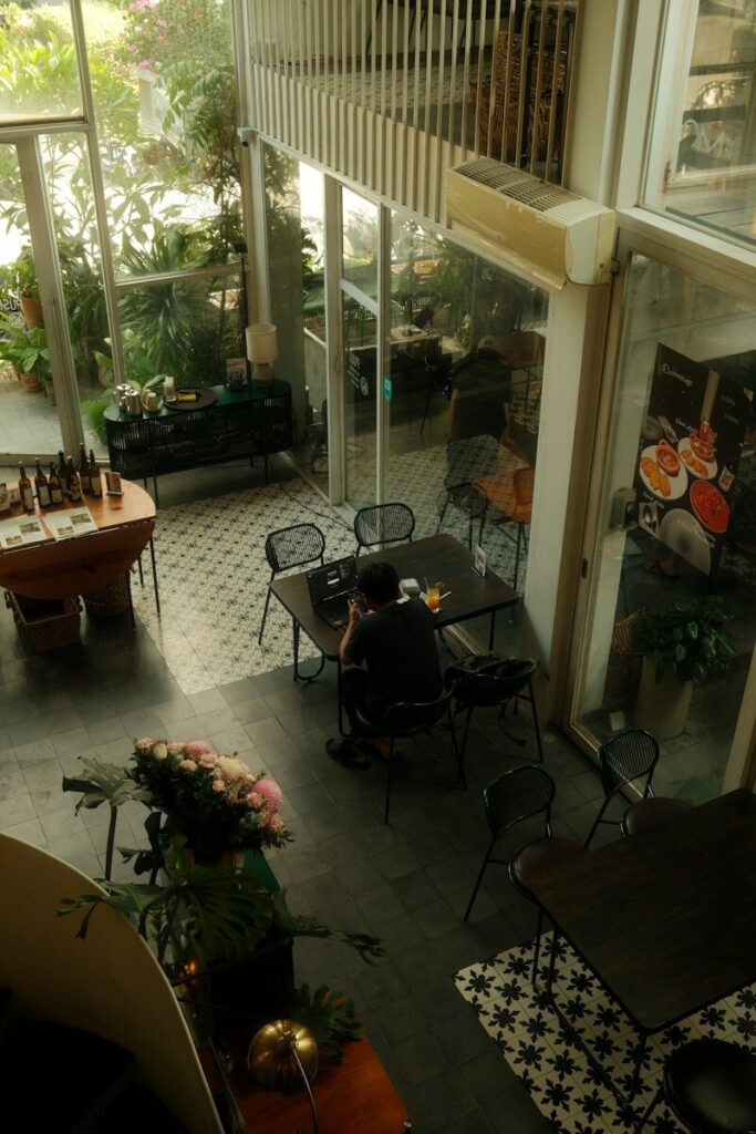 A person sits at a table in a bright cafe